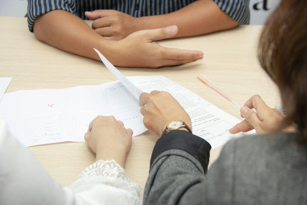 Adviser and client reviewing insurance policy documents at a meeting table
