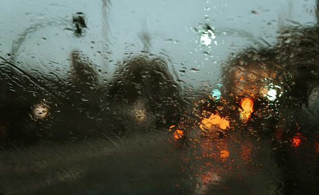 photo of a rain hitting a car window
